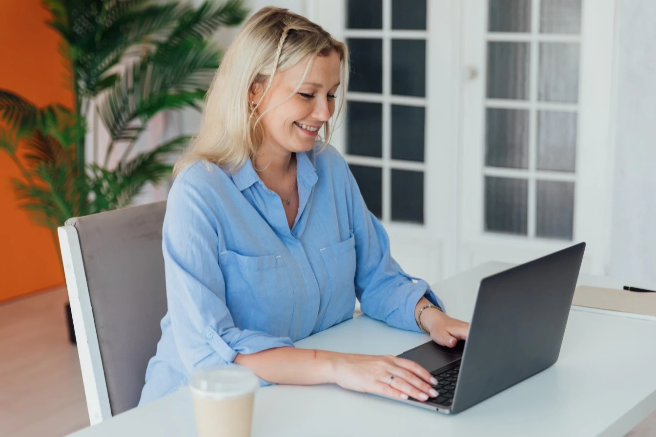 Happy woman using laptop to make an NDIS referral