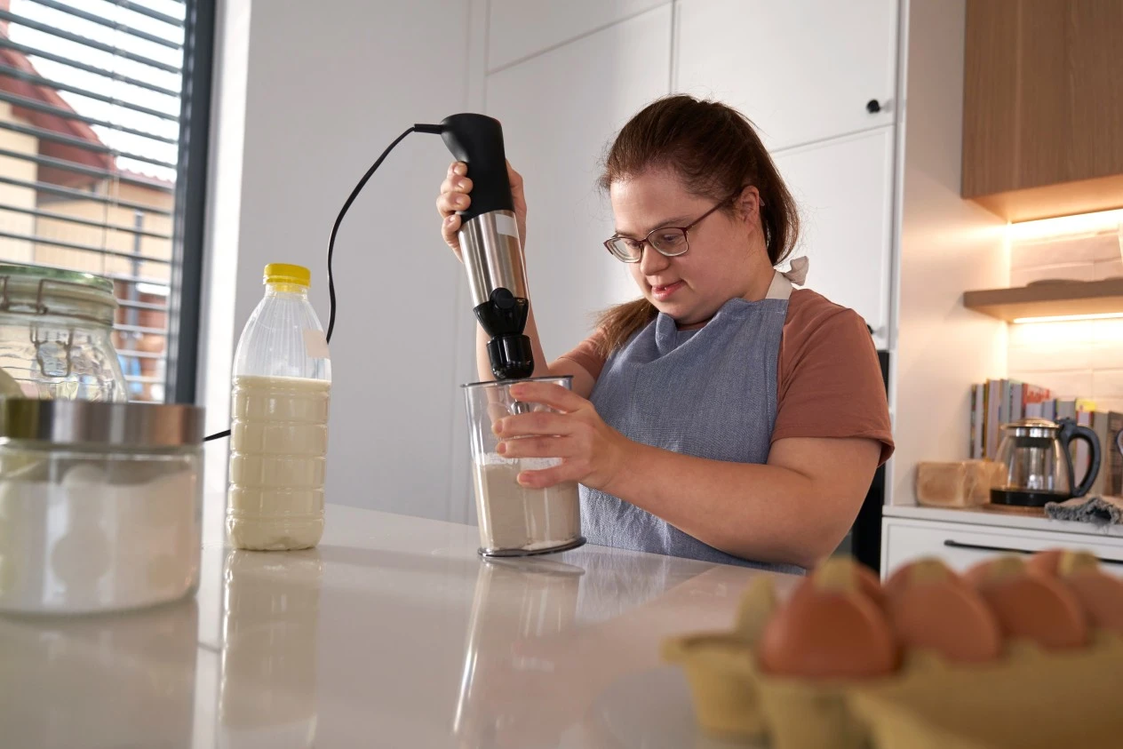 Disabled woman with down syndrome baking in kitchen