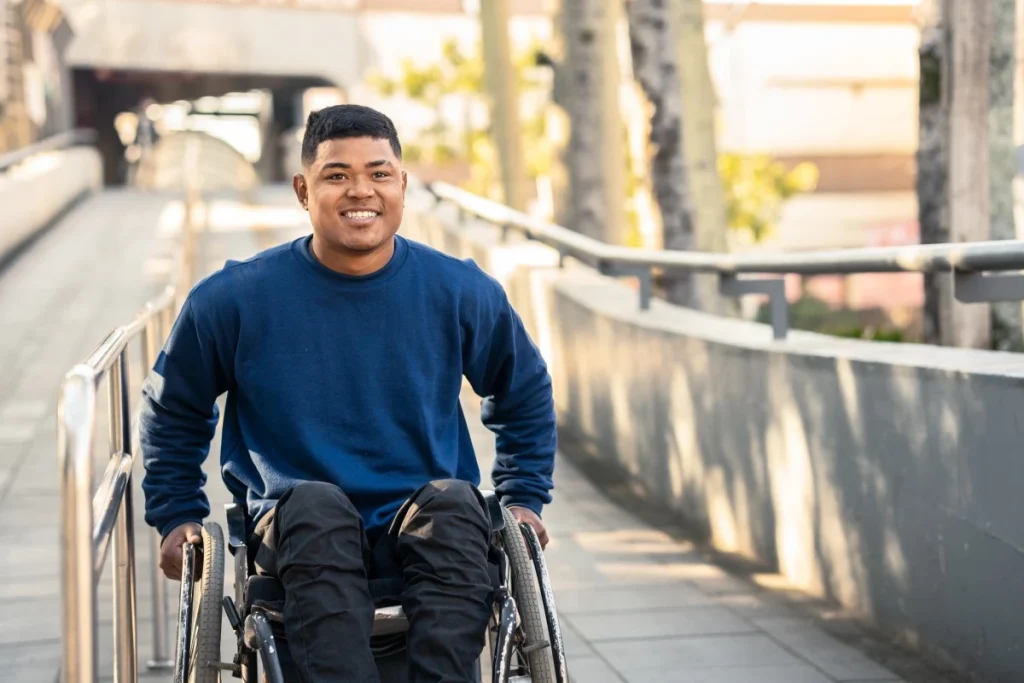 Happy man in wheelchair smiling outside